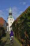 Herbstliche Gasse mit Radwanderin