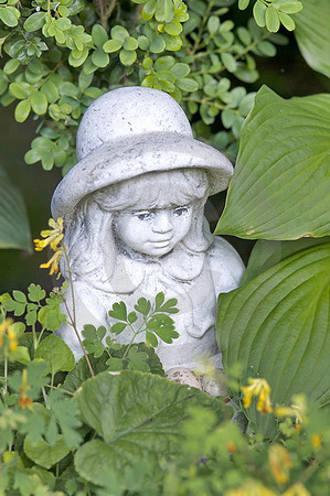 Mädchen-Skulptur im Blumenbeet